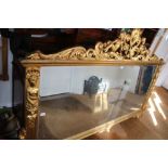 A VERY LARGE FANCY GILT FRAMED OVER MANTEL RECTANGULAR BEVELLED PLATE MIRROR