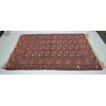 A HAND WOVEN WOOL FLOOR CARPET, having triple rows of elephant feet, within multi-guard borders,