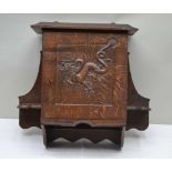 A 20TH CENTURY CRAFTSMAN BUILT OAK HANGING CUPBOARD with carved dragon panelled single door, the