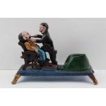 AN EARLY 20TH CENTURY CAST IRON NOVELTY DENTIST MECHANICAL MONEY BOX, polychrome painted, the
