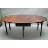 A 19TH CENTURY MAHOGANY FINISHED TWIN FLAP DINING TABLE, supported on plain square form tapering