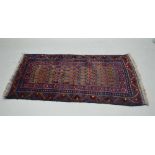 A BLUE GROUND WOVEN WOOL FLOOR RUG , of tapering rectangular form, with stylised floral central