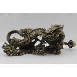 A LATE 19TH CENTURY CHINESE CAST WHITE METAL IMPERIAL DRAGON, clutching the pearl of wisdom in his