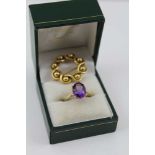 A LARGE AMETHYST SET LADY'S DRESS RING, stamped 10k and a gold coloured metal circular LAPEL