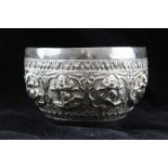 AN EARLY 20TH CENTURY SILVER THAI BOWL, embossed border of dancing figures / deities, 13cm in