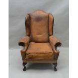 A LATE 19TH / EARLY 20TH CENTURY LEATHER COVERED WINGBACK ARMCHAIR, with decorative stud work,