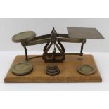 A SET OF EARLY 20TH CENTURY BRASS POSTAL SCALES, an oak base with a graduated set of weights from