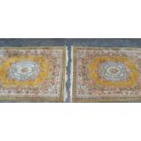 A PAIR OF GOLD & YELLOW GROUND CHINESE WASH WOOL FLOOR CARPETS, having floral decorated central