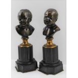 A PAIR OF BRONZE BABY PORTRAIT BUSTS, smiling and crying, raised on slate columns, c.1900, 24cm high