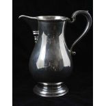 C.J. VANDER LTD. A GEORGIAN DESIGN SILVER ALE JUG of baluster form with scroll handle, on circular