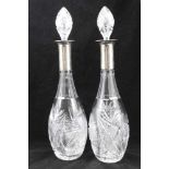 A PAIR OF CUT GLASS DECANTERS, of tear drop form, with white metal collars, stamped .800, fitted