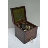 A GEORGE III MAHOGANY TRAVELLING PHARMACY CABINET, the hinged cover with brass handle, containing