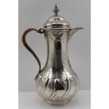 EMICK ROMER A GEORGE II SILVER JUG, the hinged cover with urn finial, repousse decoration with
