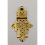 AN 18CT GOLD PENDANT of Eastern tracery design, hinged section with suspension ring, 10g
