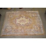 AN OLD GOLD GROUND CHINESE WASHED WOOL FLOOR CARPET of floral form, with two slender guard