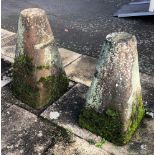 TWO SANDSTONE TAPERING COLUMNS each having one side cut, presumably for a bench seat, the tallest