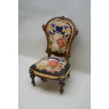 A VICTORIAN FANCY CARVED WALNUT FRAMED NURSING STYLE CHAIR, with floral wool work back and seat pad,