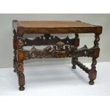 A CAROLEAN DESIGN CARVED OAK FRAMED STOOL, having crown and dolphin front rail, with split cane