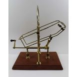 A 20TH CENTURY FRENCH MECHANICAL BRASS WINE DECANTING MECHANISM with crank handle operation on