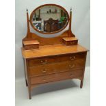 A FIRST-QUARTER 20TH CENTURY INLAID WALNUT DRESSING TABLE having central oval bevelled plate mirror,