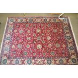 A LATE 20TH CENTURY WOVEN WOOLLEN PERSIAN DESIGN FLOOR CARPET, with a floral central field on