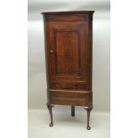 A GEORGE III OAK CORNER CABINET, fitted single door, with drawer to base, raised upon a stand with