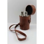 A LEATHER SPIRIT FLASK CASE, containing three sectional glass flasks, with plated mounts, the case