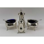 A PAIR OF EDWARDIAN SILVER SALTS, having decorative rims, raised on four paw feet, with blue glass