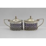 A PAIR OF GEORGIAN DESIGN SILVER MUSTARD POTS, hinged covers and pierced oval bodies, Chester