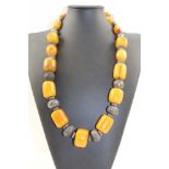 AN EASTERN NECKLACE, white metal and amber graduated beads, 80cm long
