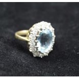 AN AQUAMARINE & DIAMOND LADY'S RING, facet cut oval central stone