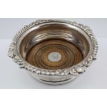 A GEORGIAN DESIGN SILVER-PLATED WINE BOTTLE COASTER having deep gallery with acanthus scroll rim,