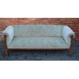 AN EDWARDIAN CHESTERFIELD SOFA, with carved oak supports, having carved rosette decoration,