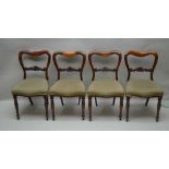 A SET OF FOUR ROSEWOOD DINING CHAIRS with carved bar backs, overstuffed seat pads, turned fore