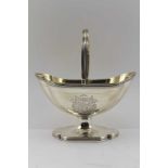 A GEORGE III SILVER SUGAR BASKET, swing handle, gilded interior on shaped platform foot, London