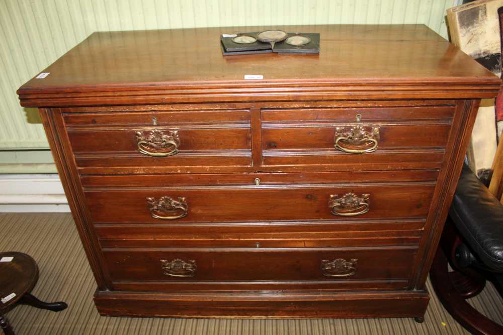 A LATE 19TH CENTURY WALNUT COLOURED FOUR-DRAWER CHEST on plain plinth base