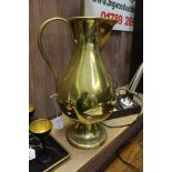 A 19TH CENTURY 'JONES & WILLIS' BRASS EWER, baluster form with circular platform foot, the handle