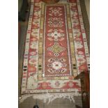 A MODERN WOVEN WOOLLEN RECTANGULAR FLOOR RUG with five lozenge centre field, flanked by multi-