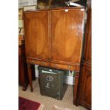 A WELL MADE REPRODUCTION MAHOGANY AND WALNUT COLOURED DRINKS CABINET having two panelled cupboard