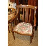 AN EDWARDIAN FANCY INLAID HIGH BACKED ARMCHAIR with serpentine fronted seat, supported on turned