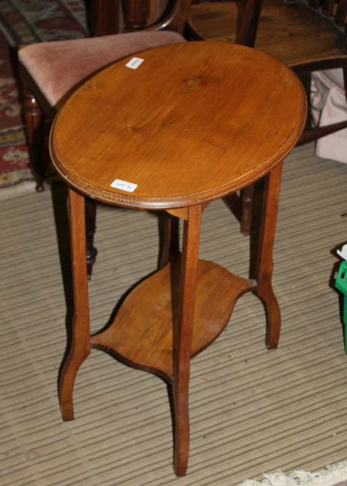 AN OAK FINISHED OVAL TOPPED OCCASIONAL TABLE on four shaped legs, with a planked undertier