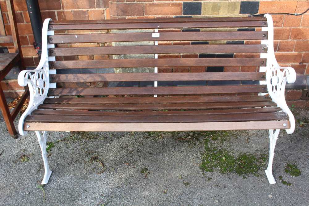 A WHITE PAINTED CAST METAL FRAMED SLATTED GARDEN TWO-SEATER BENCH together with two slatted single