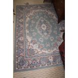 A GREEN GROUND WOVEN WOOLLEN FLOOR CARPET of stylised floral form