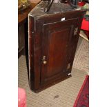 A SMALL EARLY 19TH CENTURY HANGING SINGLE DOOR CORNER CUPBOARD