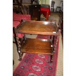 AN OAK TWO-TIER TEA TROLLEY with bobbin turned uprights