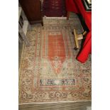 AN ANTIQUE WOVEN WOOLLEN PRAYER RUG having central orange ground mireb within the banding of Islamic