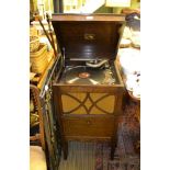 AN OAK FINISHED 'HIS MASTERS VOICE' BRANDED WIND UP GRAMOPHONE together with a series of 78RPM