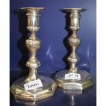 A PAIR OF SILVER ANTIQUE DESIGN CANDLESTICKS, made by the Goldsmiths & Silversmiths Company (heavily