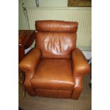 A MANUALLY RECLINING TAN ARMCHAIR