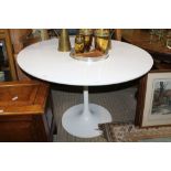 A WHITE MELAMINE CIRCULAR TOPPED TABLE on a painted metal trumpet base, after the tulip design by